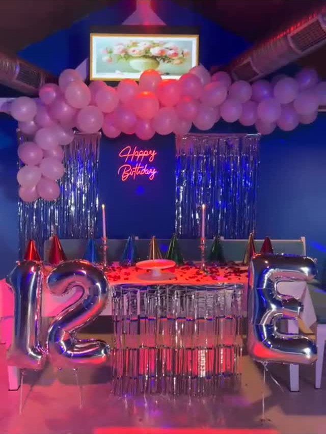 Birthday party setup with pink balloons, silver tinsel, and silver number 12 balloons.