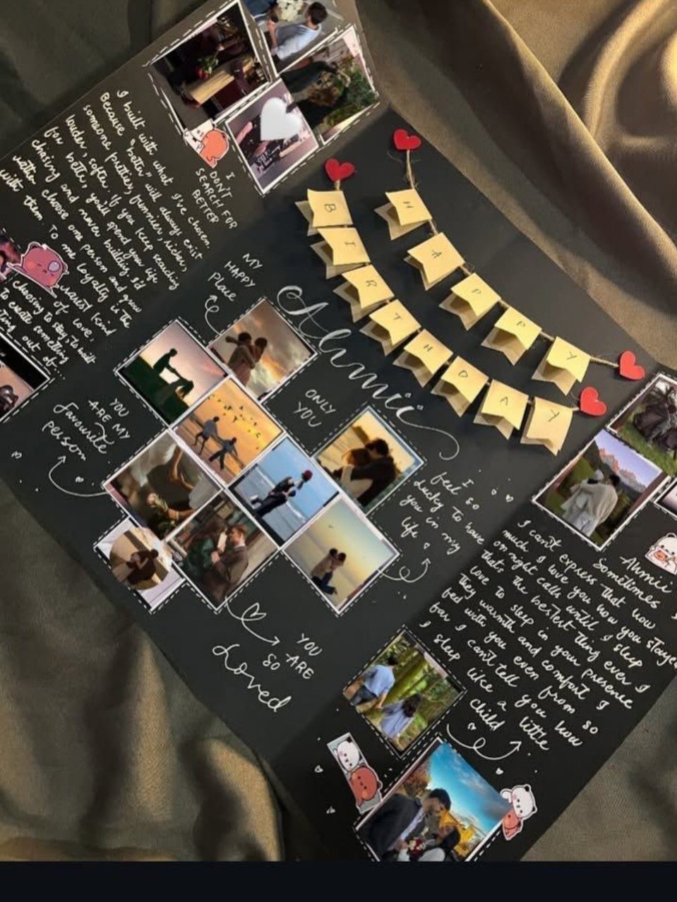 Open black scrapbook with handwritten letters, couple photos, and tiny yellow envelopes.
