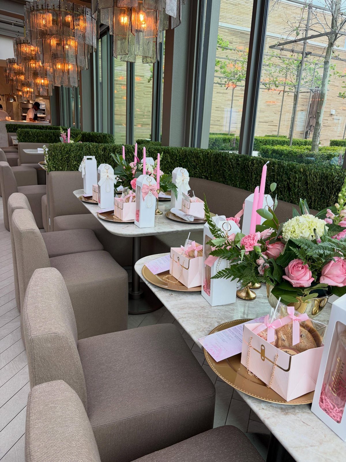 Elegant party table setting with pink gift boxes and roses in a restaurant