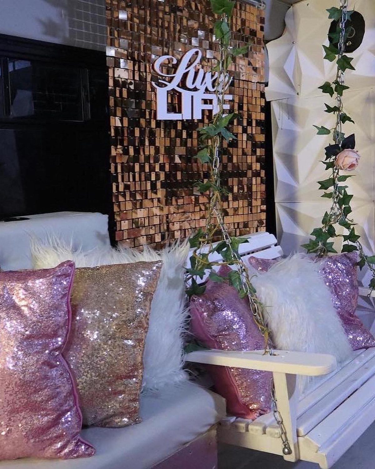 Luxury party bus interior with sequined pillows and a Lux Life wall sign.