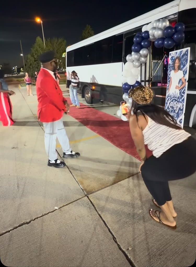 White party bus decorated with balloons and a red carpet for a celebration.