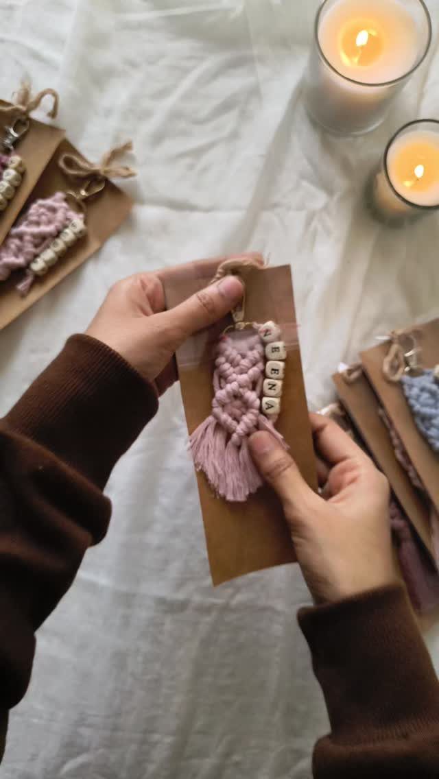 Pink macrame keychains with personalized letter beads on brown cardboard gift tags