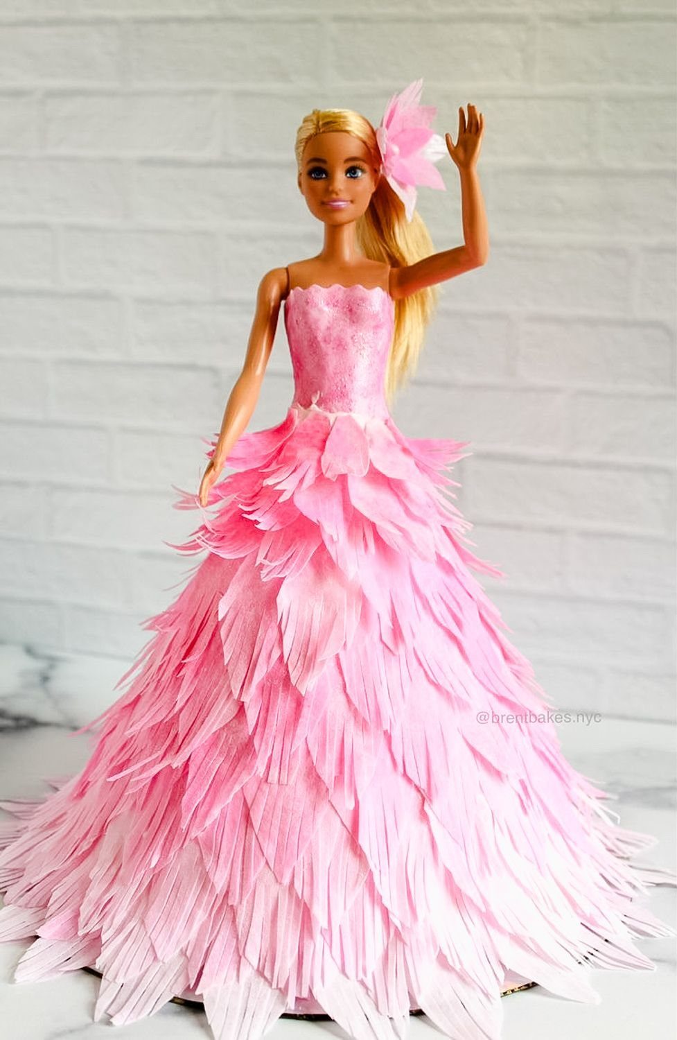 Barbie doll cake with a large, ruffled pink party dress and blonde hair.