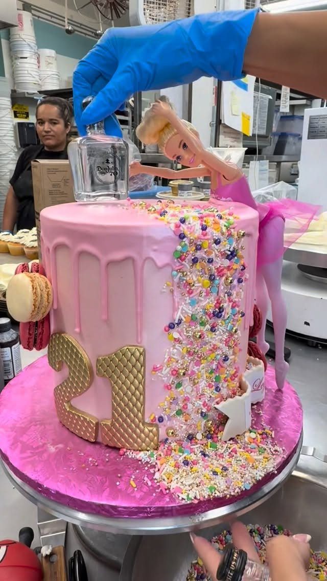 Pink Barbie birthday cake with gold 21 topper and miniature liquor bottle.