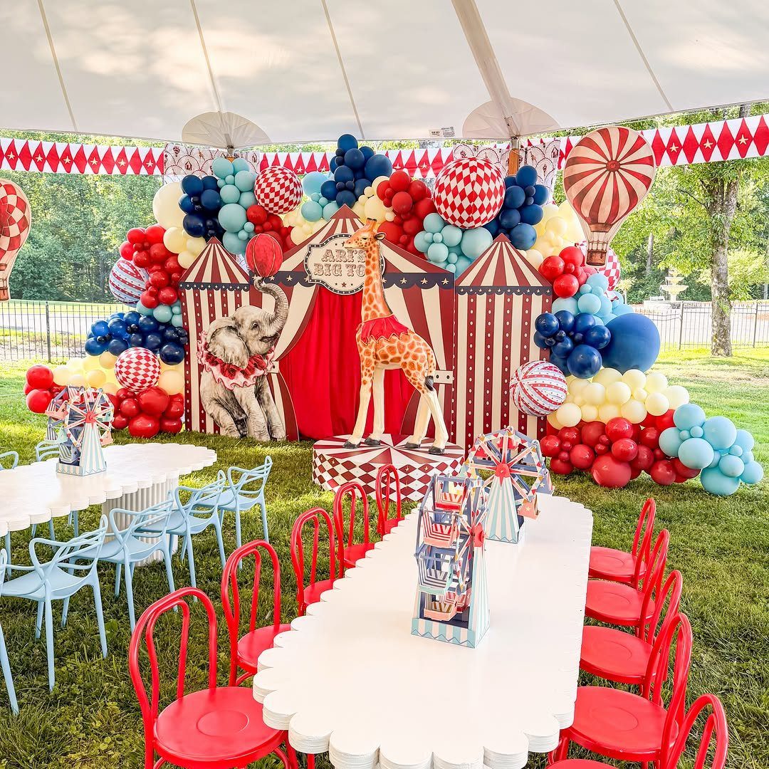 Circus party setup with red and white stripes, animal cutouts, and colorful balloons.