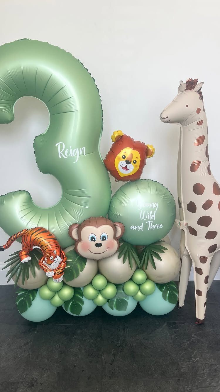 Animal-themed balloon arrangement with a large green number three and jungle animals.