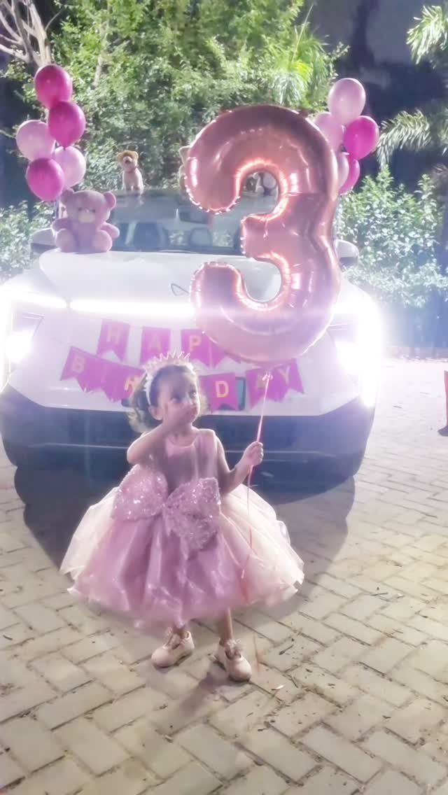 Young girl in pink princess dress and tiara holding a number 3 balloon.