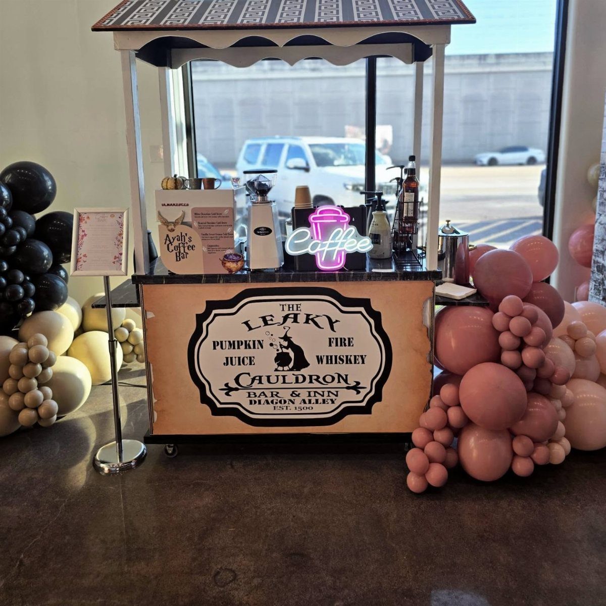 Harry Potter themed coffee cart with Leaky Cauldron signage and pink balloon decorations.