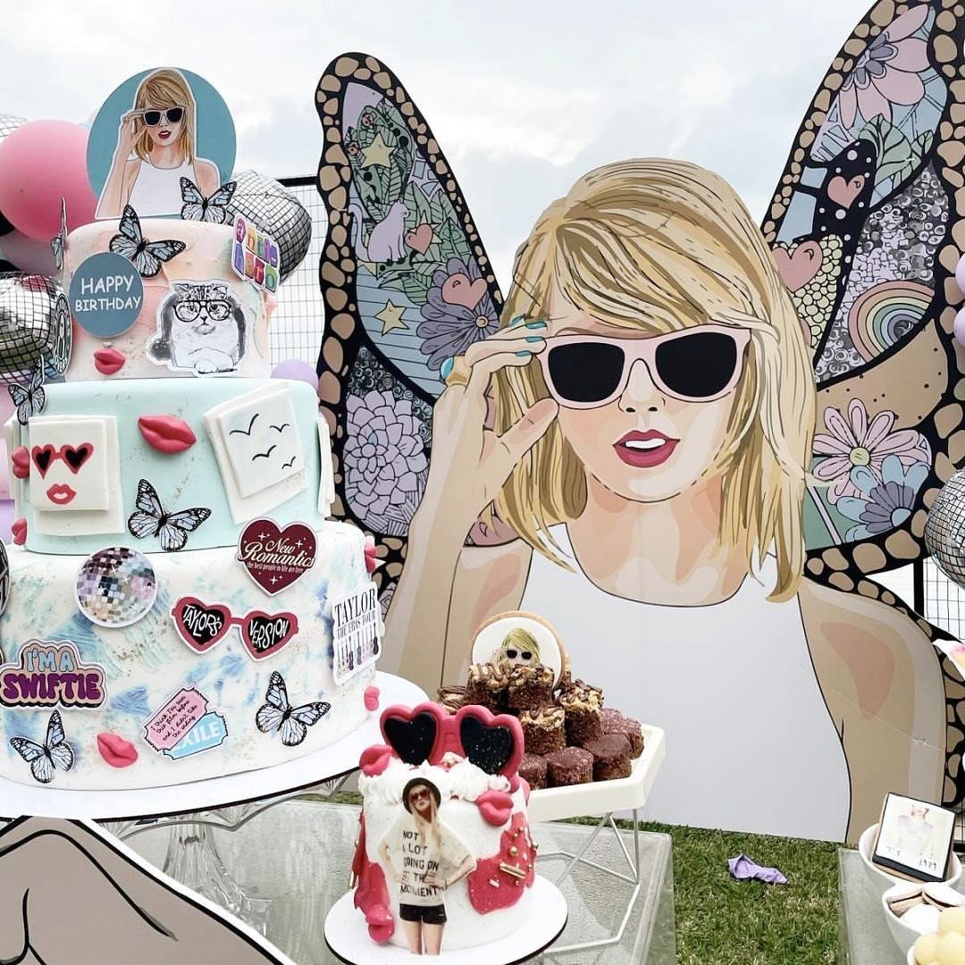 Taylor Swift themed birthday cake and large cardboard cutout with butterfly wings