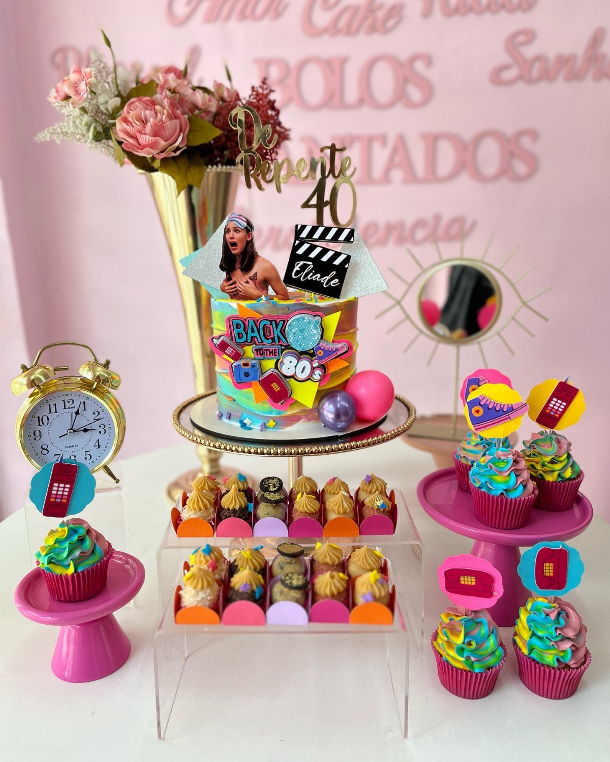 Neon 80s themed birthday cake with matching cupcakes and gold alarm clock