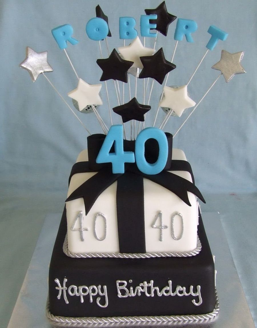 Two-tier black and white square birthday cake with blue name and number toppers.