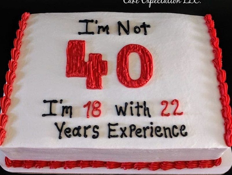 White rectangular cake with red borders and funny 40th birthday message in frosting