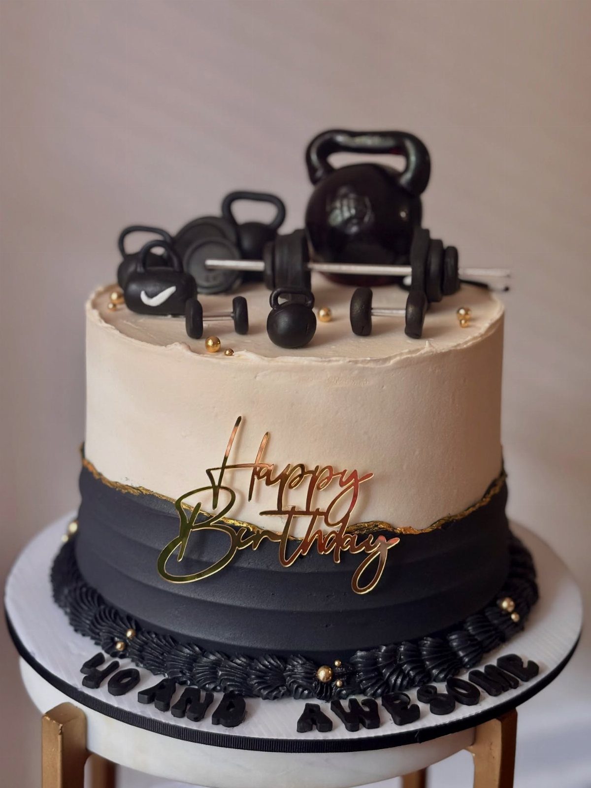 Gym themed birthday cake with edible kettlebell, dumbbells, and gold birthday topper.