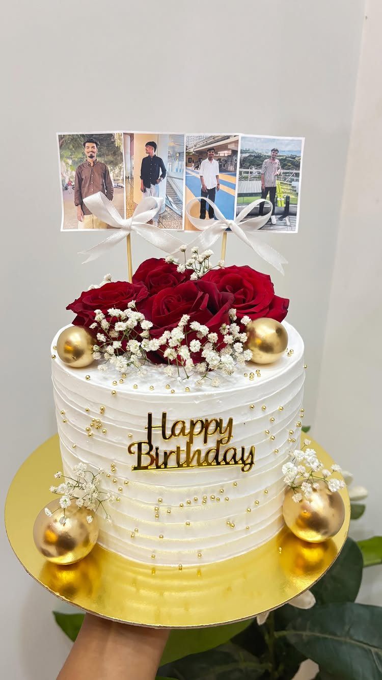 White birthday cake with red roses and personalized photos on top.