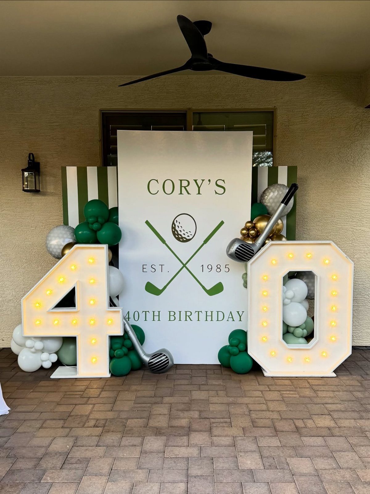 Golf themed 40th birthday decorations with large lit numbers and green balloons