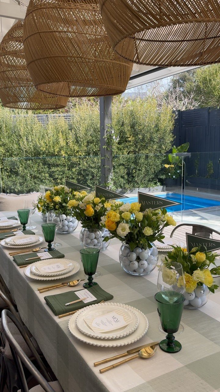 Dining table centerpieces featuring yellow flowers and white golf balls in glass bowls.