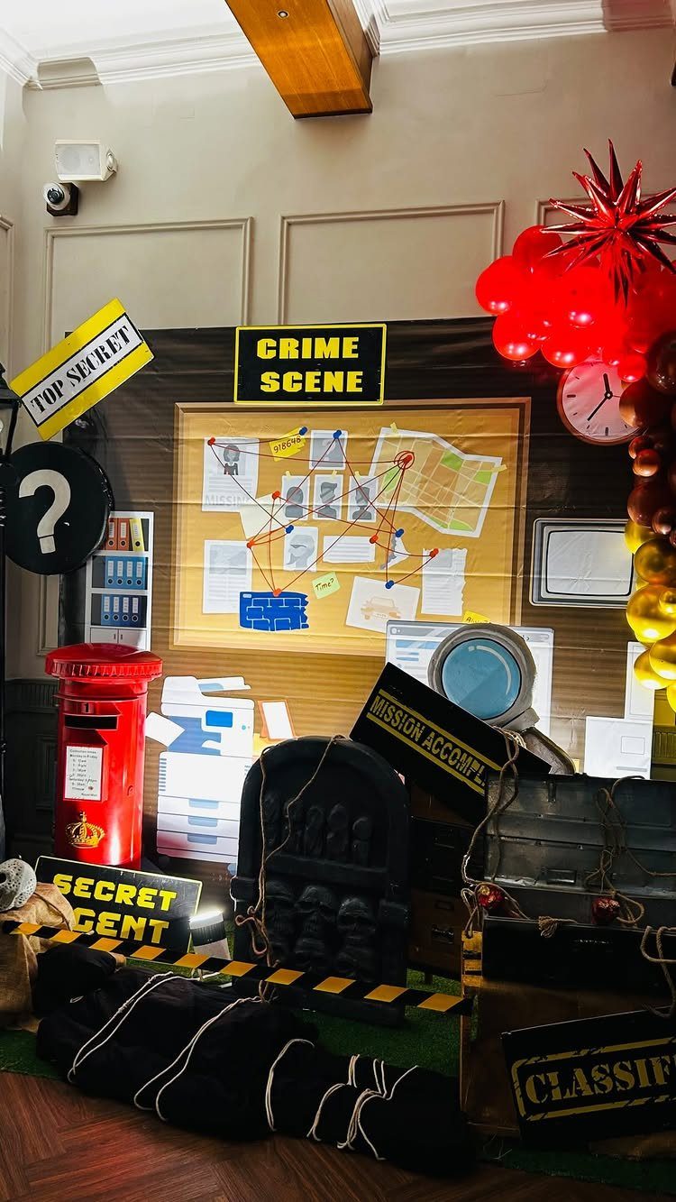 Detective themed party setup with crime scene board, red post box, and balloons.