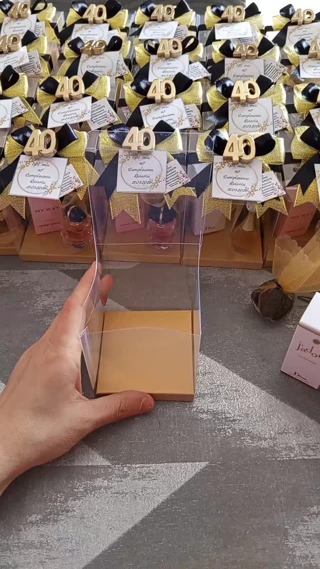 Clear gift boxes with gold 40 toppers and ribbons for birthday party favors