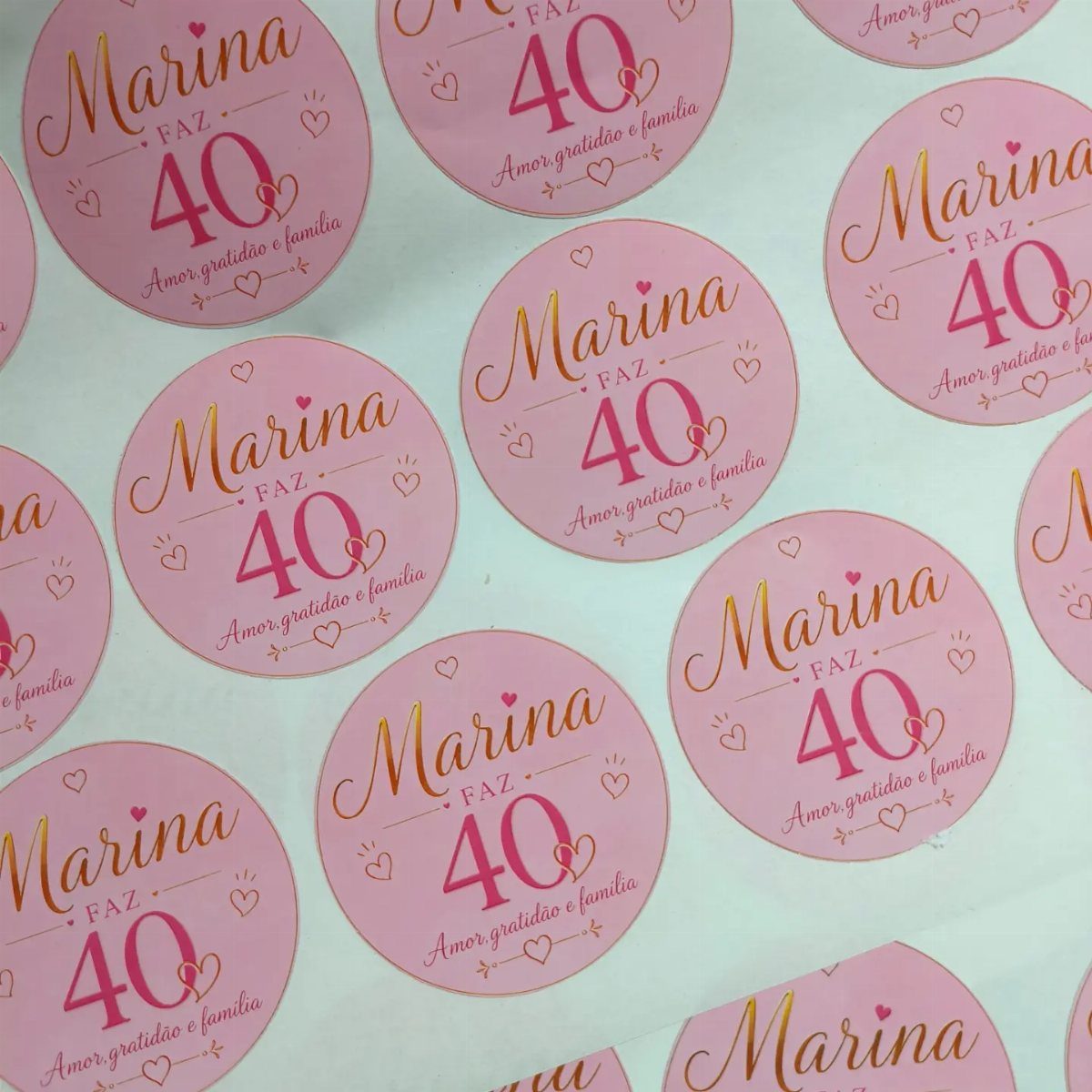 Round pink stickers with gold text celebrating Marina's 40th birthday with heart accents.