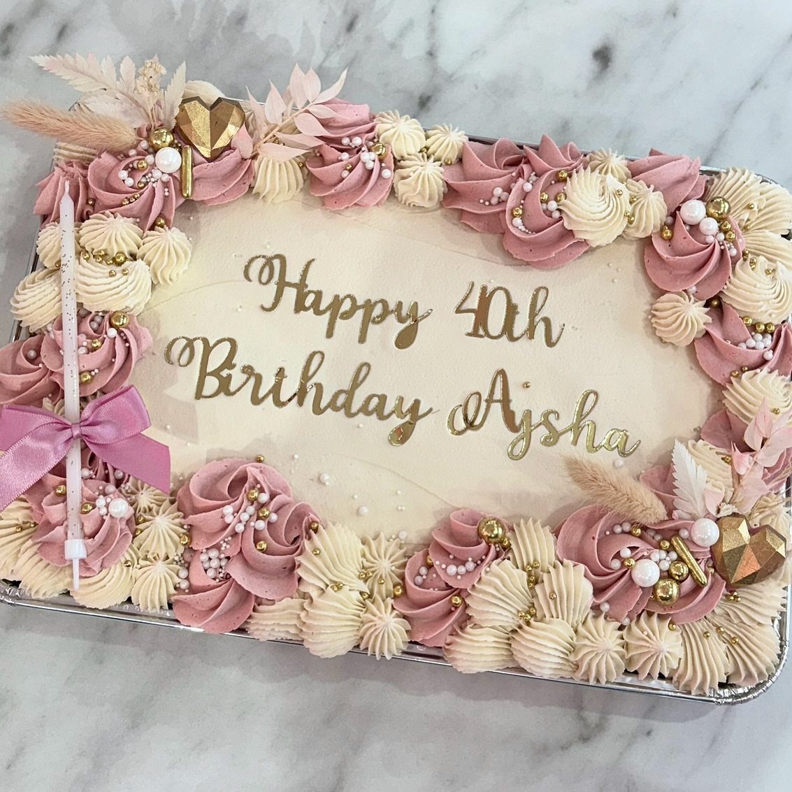 Rectangular 40th birthday sheet cake with pink and cream frosting and gold lettering.