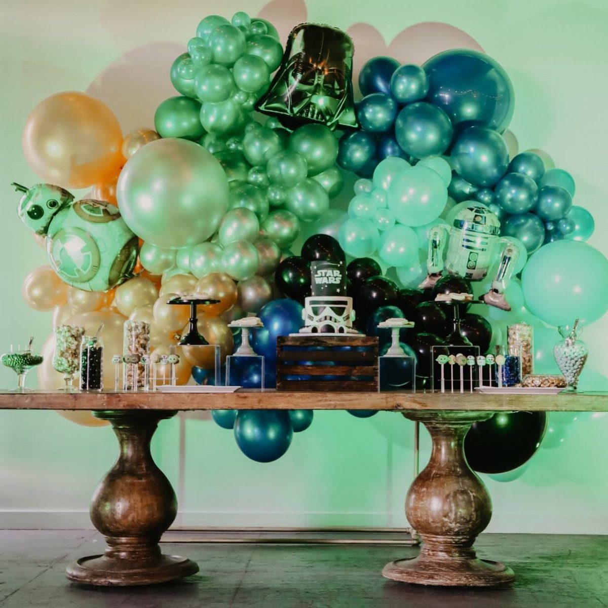 Star Wars themed dessert table with a large green and blue balloon arch.