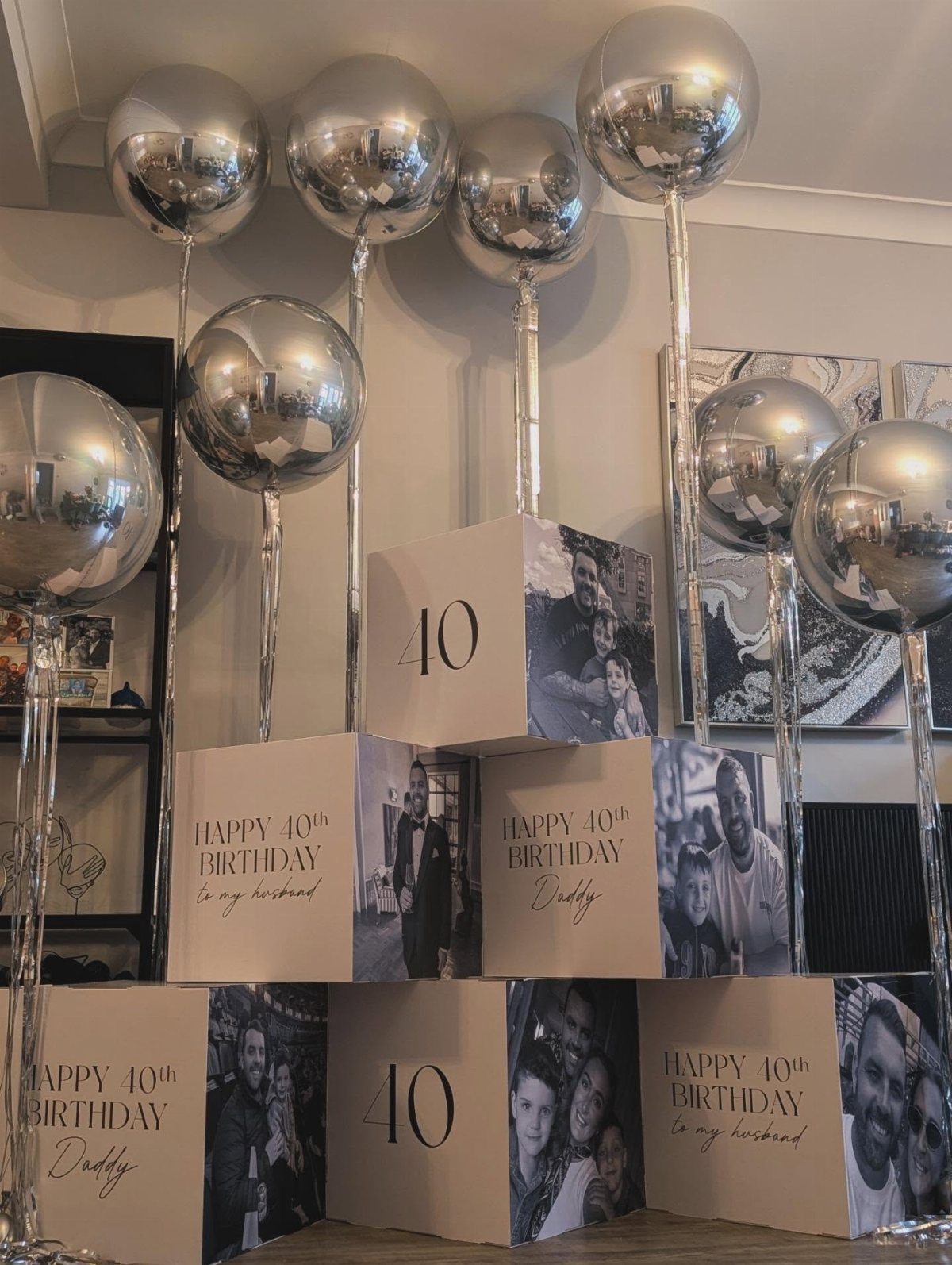 Silver balloons and personalized white gift boxes celebrating a 40th birthday for him.