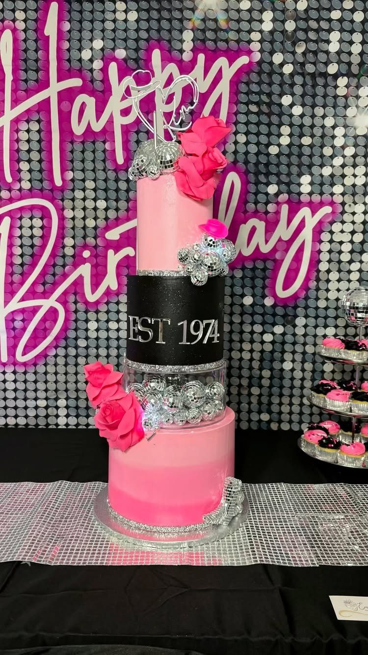Three-tier pink and black birthday cake decorated with silver disco balls and roses.