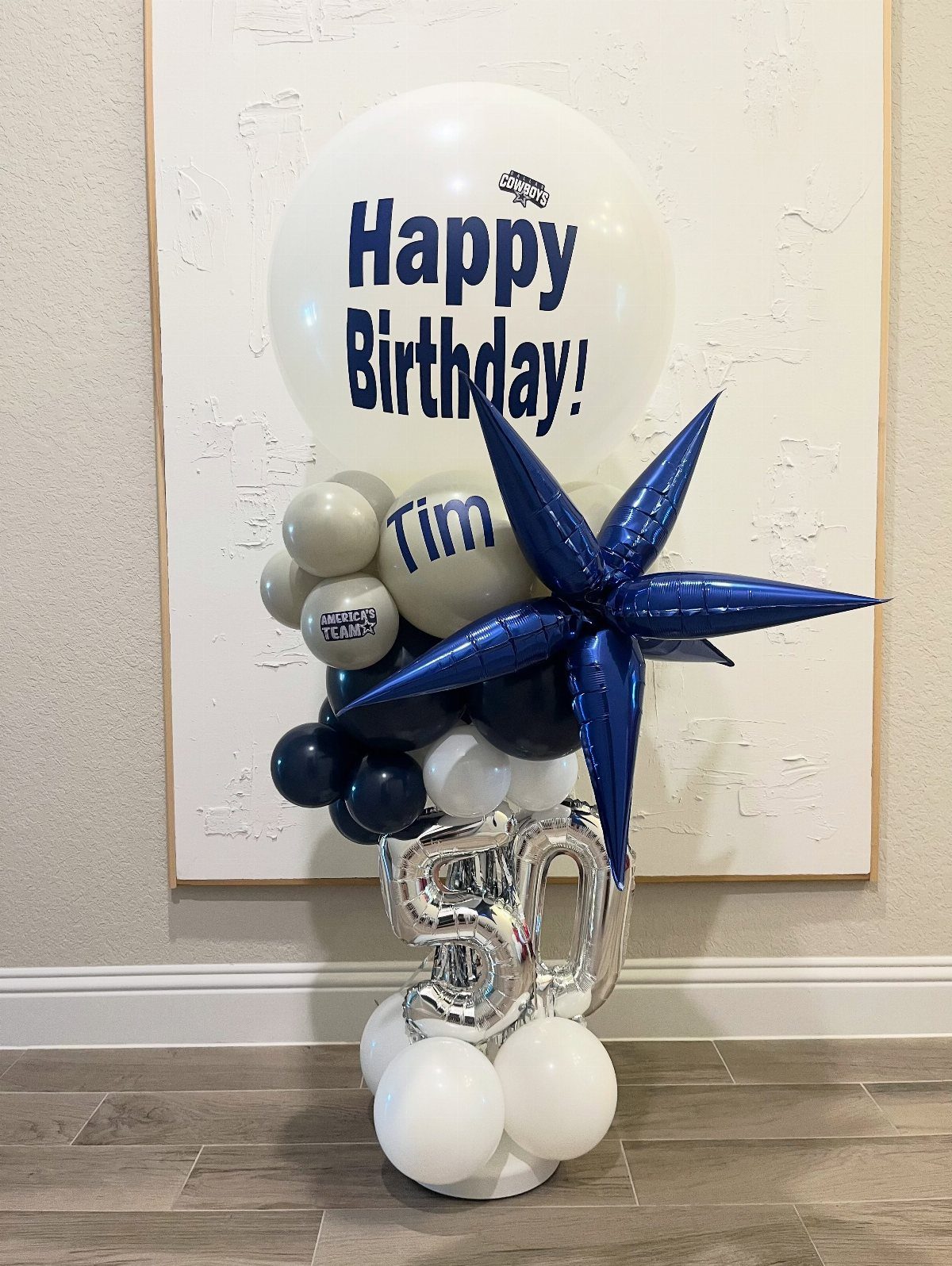 Balloon arrangement with a blue star, silver number 50, and personalized birthday messages.