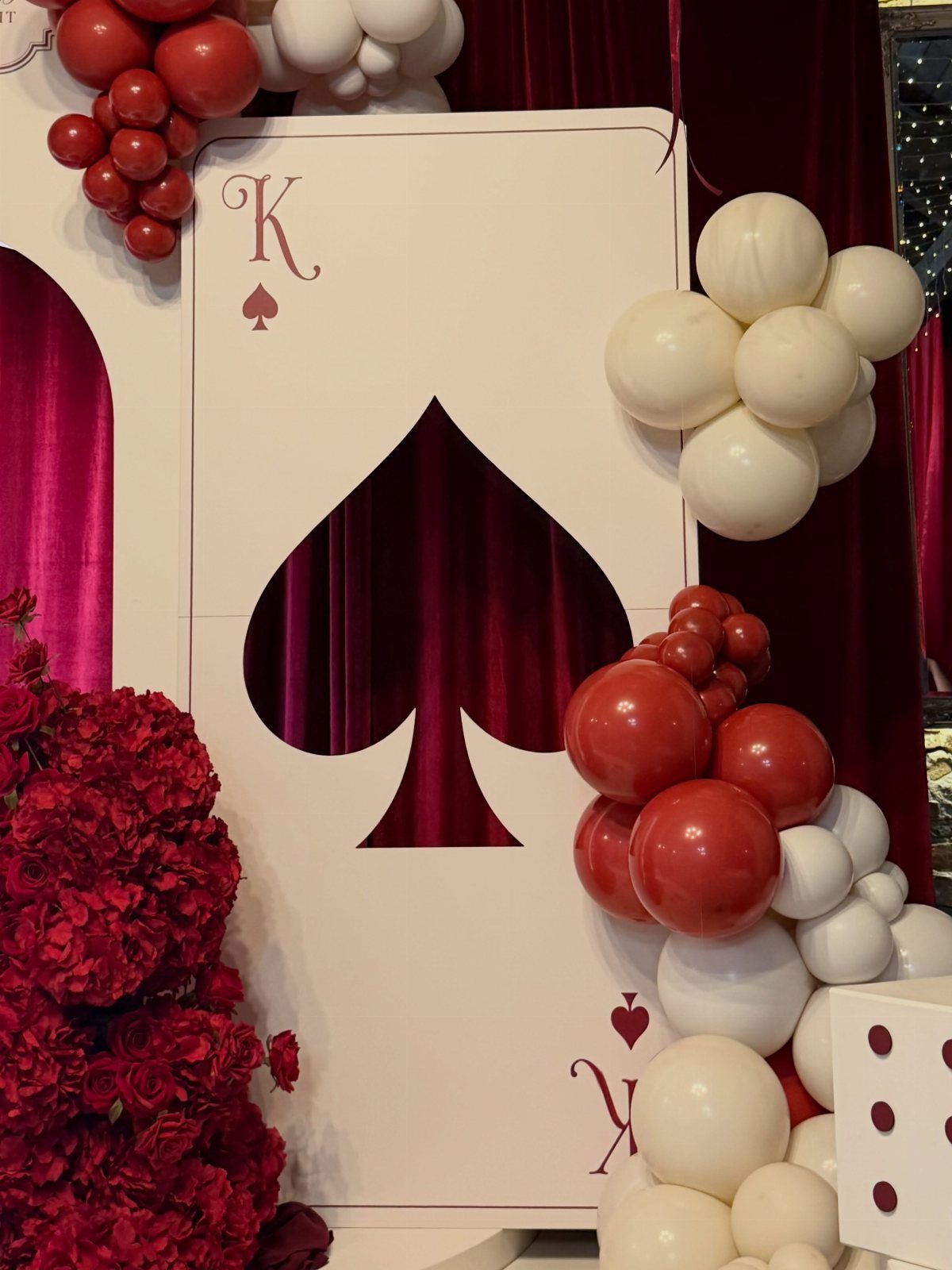 King of Spades playing card cutout with red and white balloons and flowers.