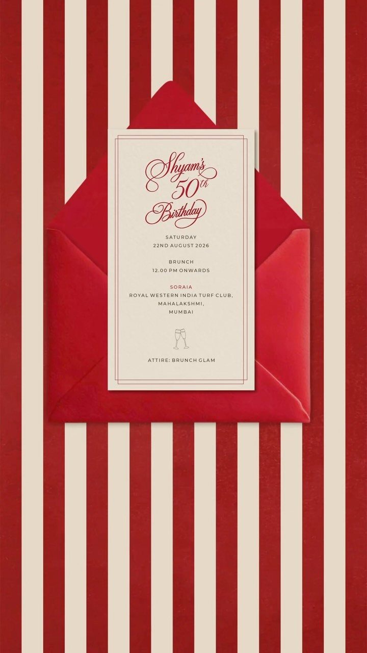 White 50th birthday invitation card in a red envelope on striped background