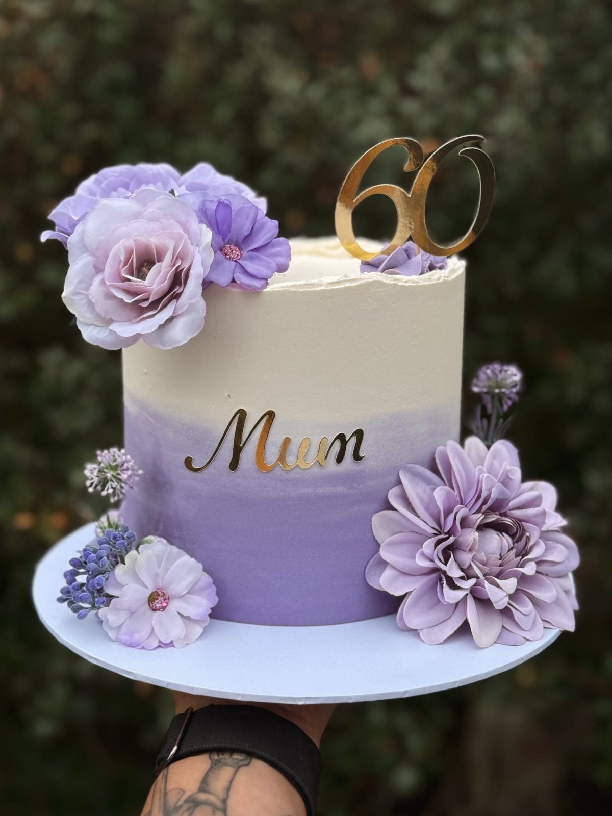 Purple ombre cake with gold Mum and 60 toppers and purple flowers.