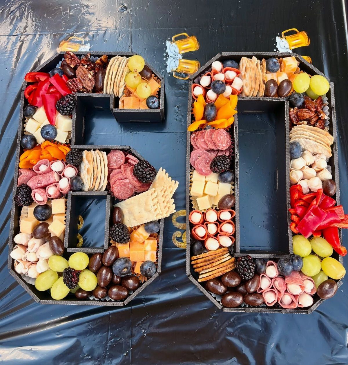 Charcuterie board shaped like the number 60 filled with meats, cheeses, and fruits.