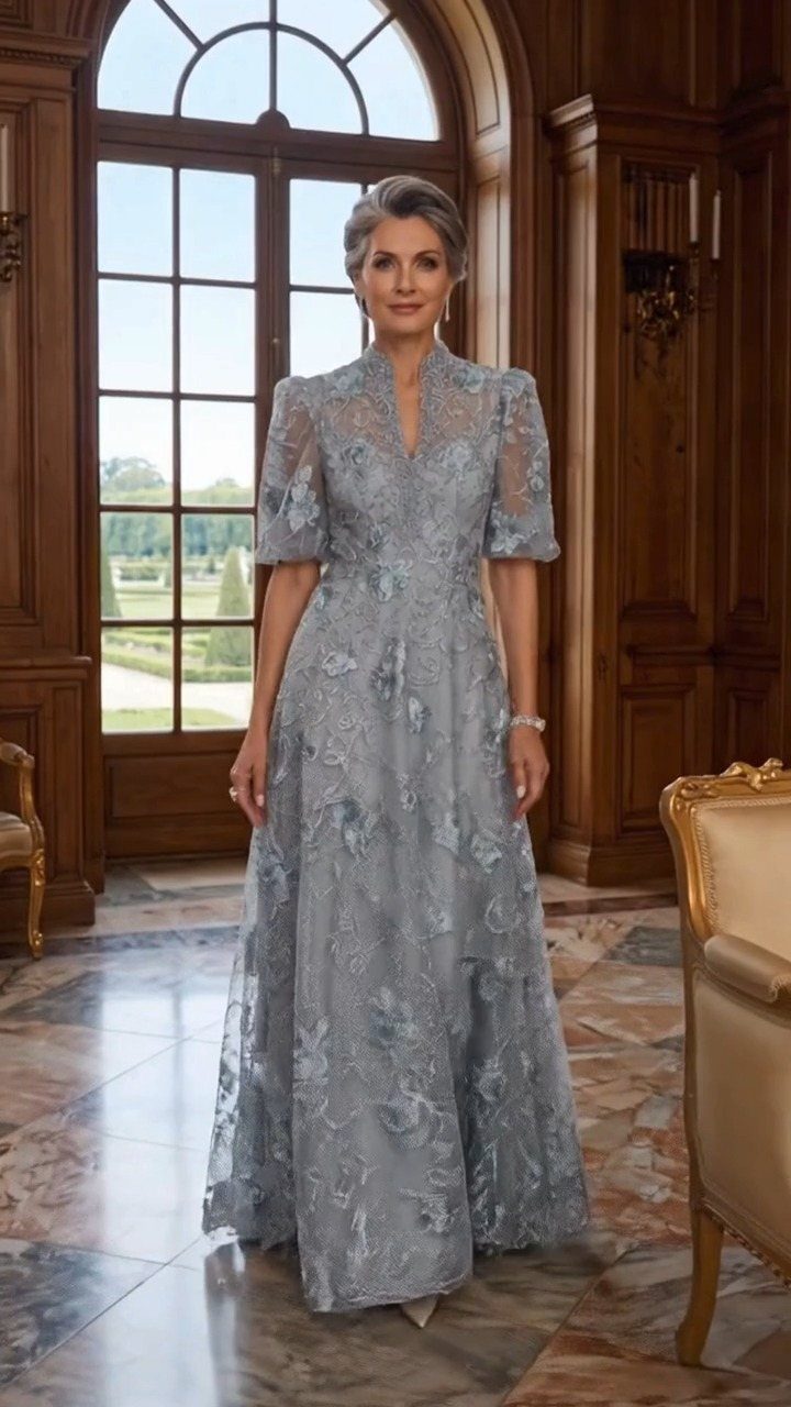 Mature woman wearing an elegant light blue lace floor-length gown in a classic room