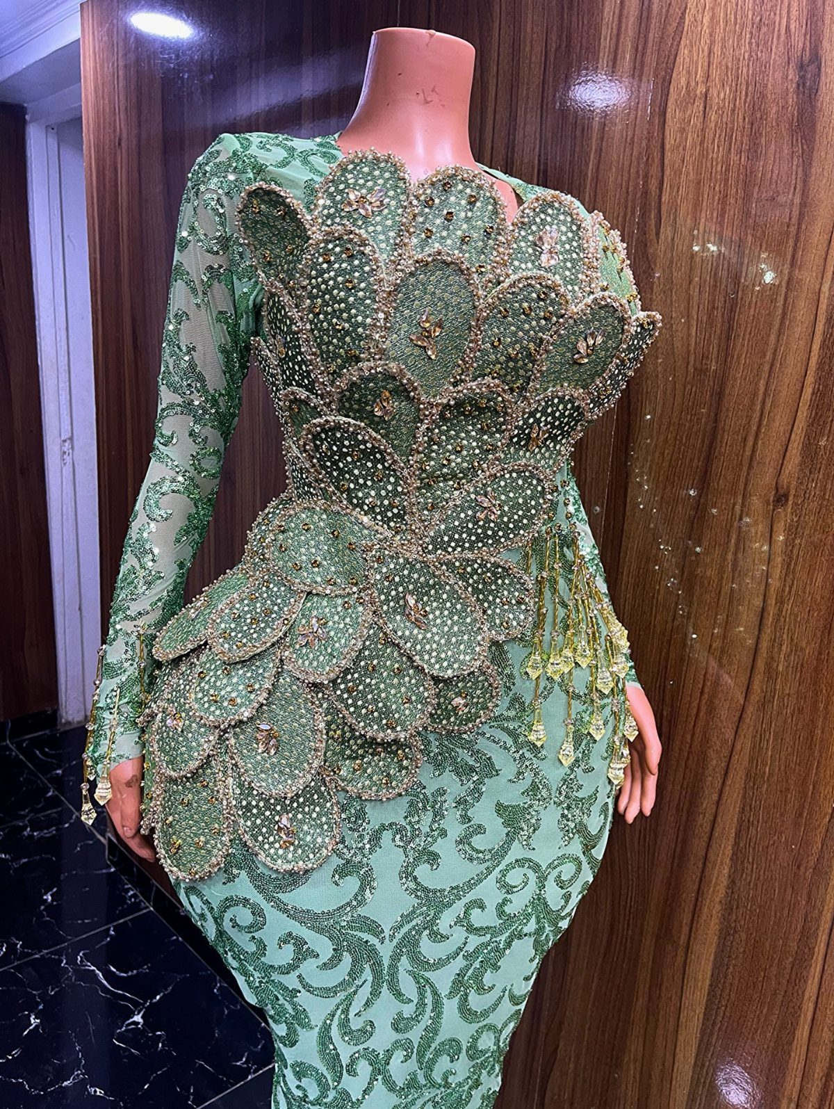 Green embellished cocktail dress with 3D beaded scales on a mannequin