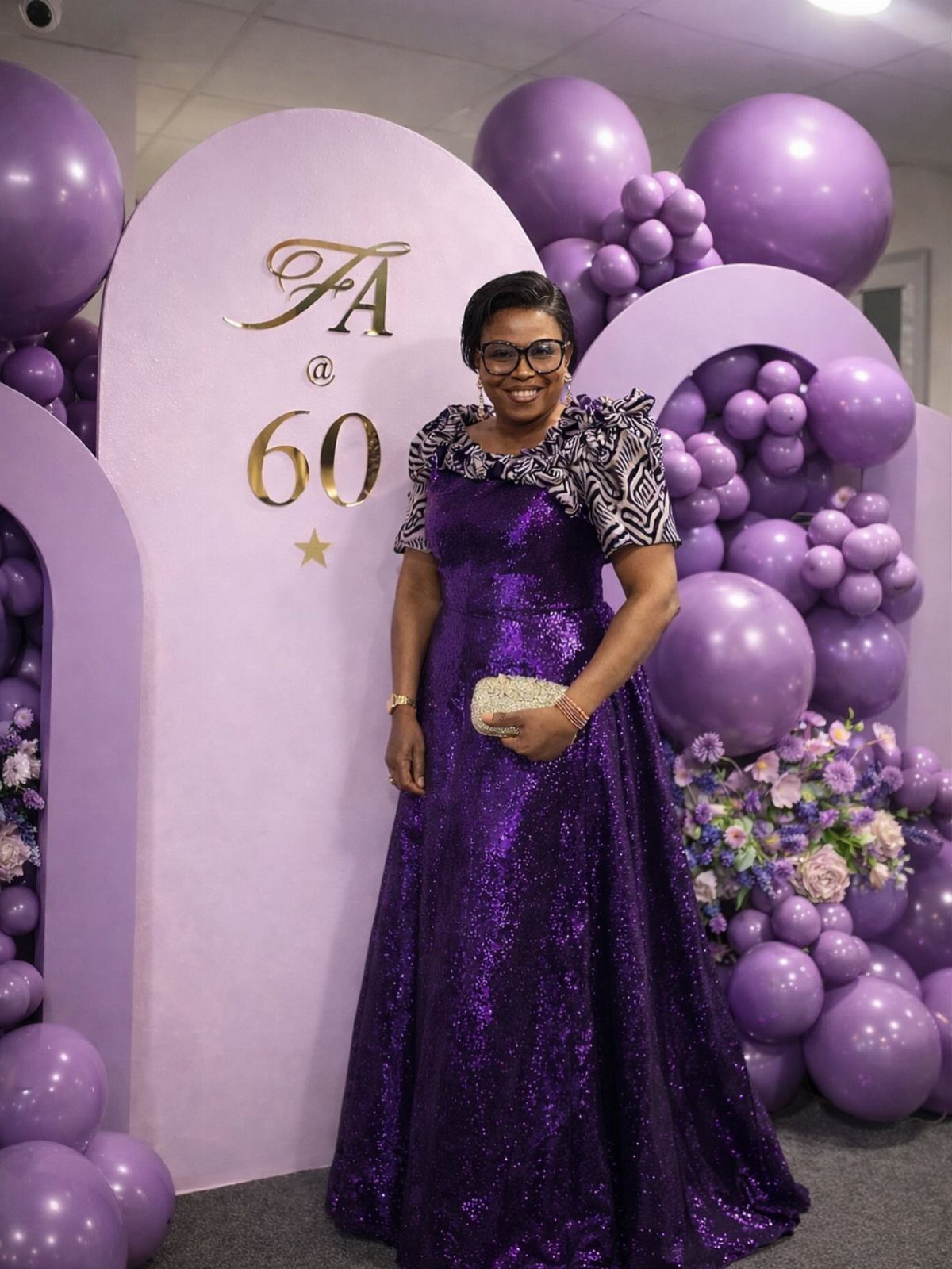 Woman in a sparkling purple gown posing before a 60th birthday backdrop.