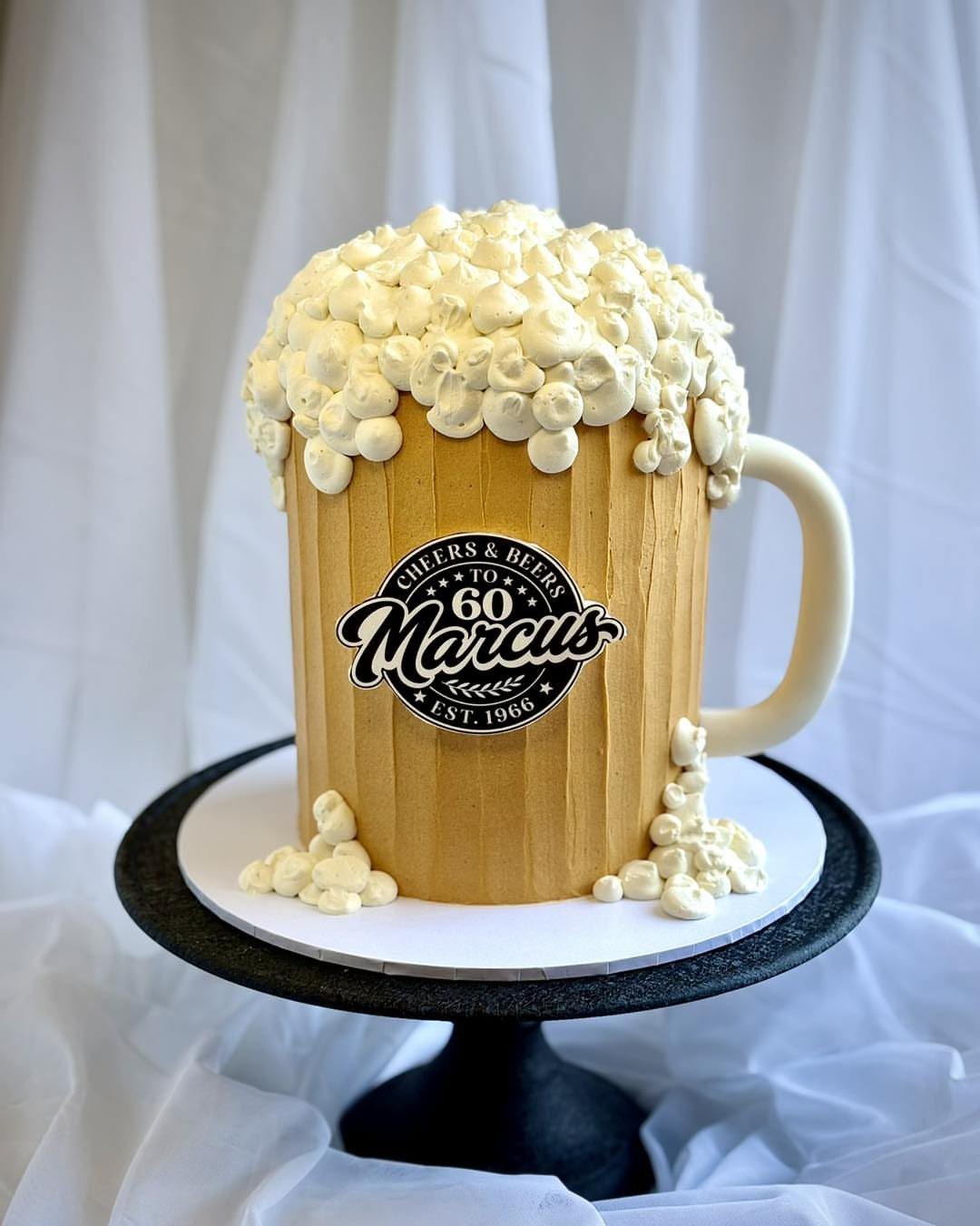 Beer mug shaped cake with white foam frosting and 60th birthday label