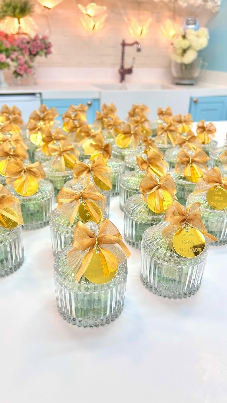 Small ribbed glass jars filled with mints, tied with gold ribbons and tags.