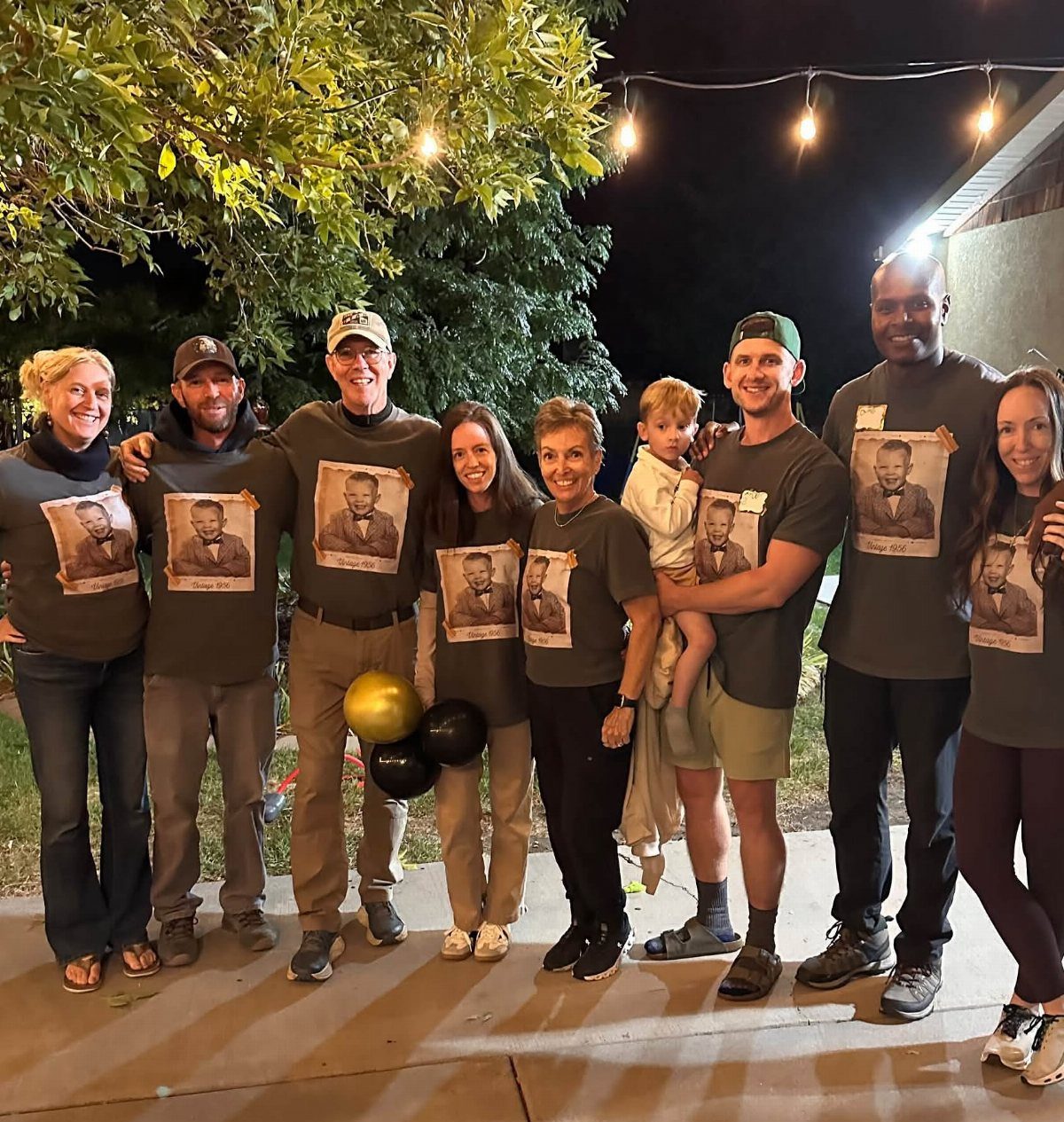 Group of people wearing matching t-shirts with a portrait for a celebration.