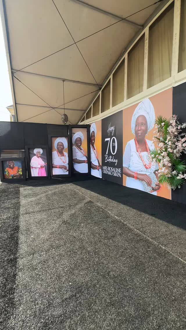 Birthday celebration backdrop with large portrait and smaller framed photos of a woman.