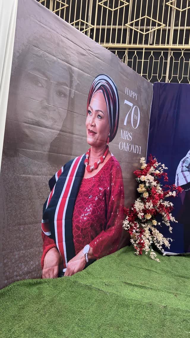 Printed birthday backdrop of a woman celebrating her 70th birthday with floral accents.