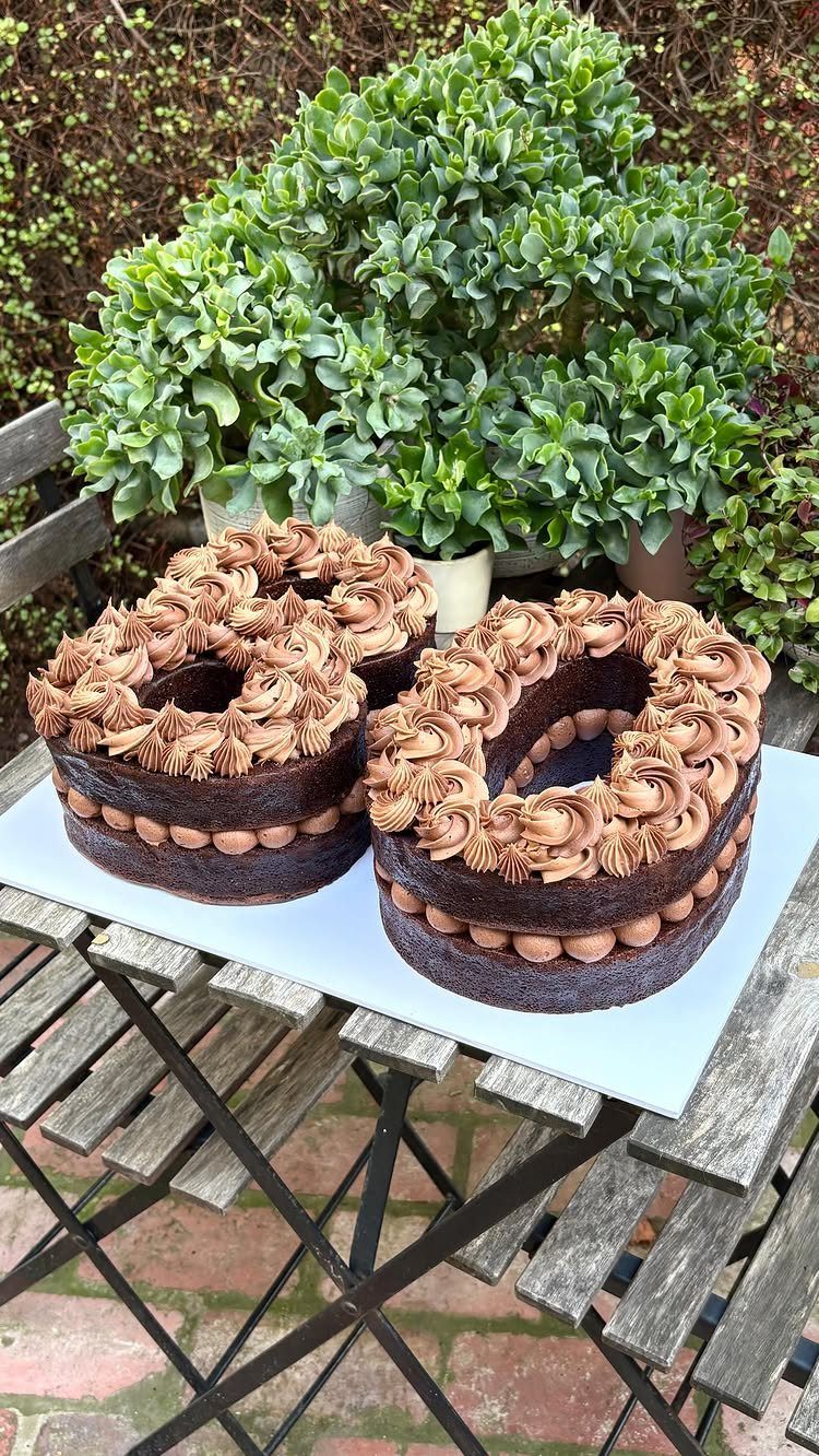 Chocolate cake shaped like the number 80 with brown frosting swirls and balls.