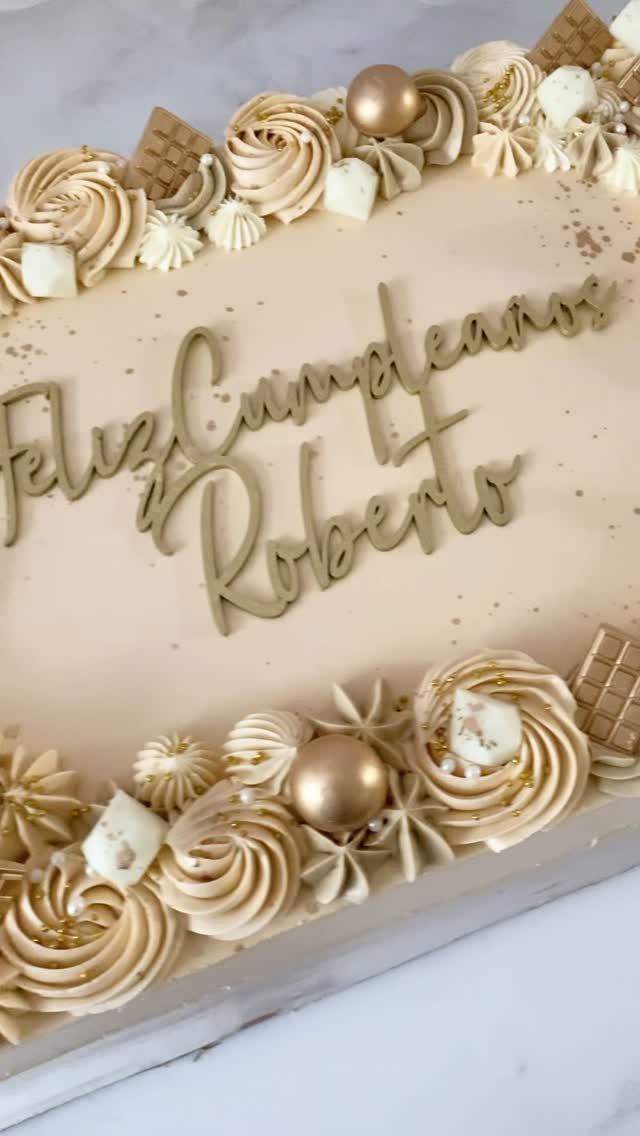 Beige sheet cake with gold lettering and buttercream swirls for Roberto's birthday.