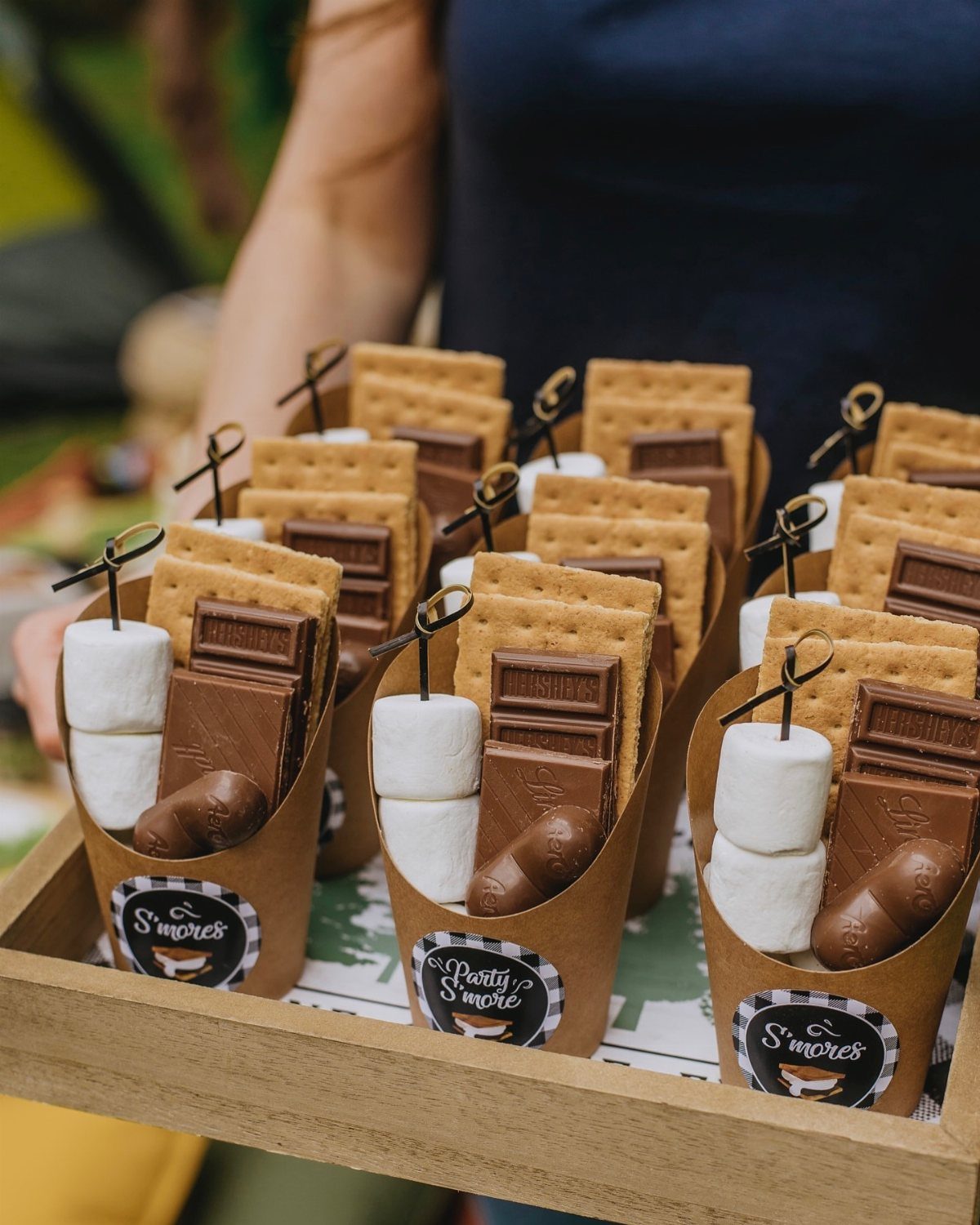 S'mores kits in paper cones with graham crackers, chocolate, and marshmallows on a tray.