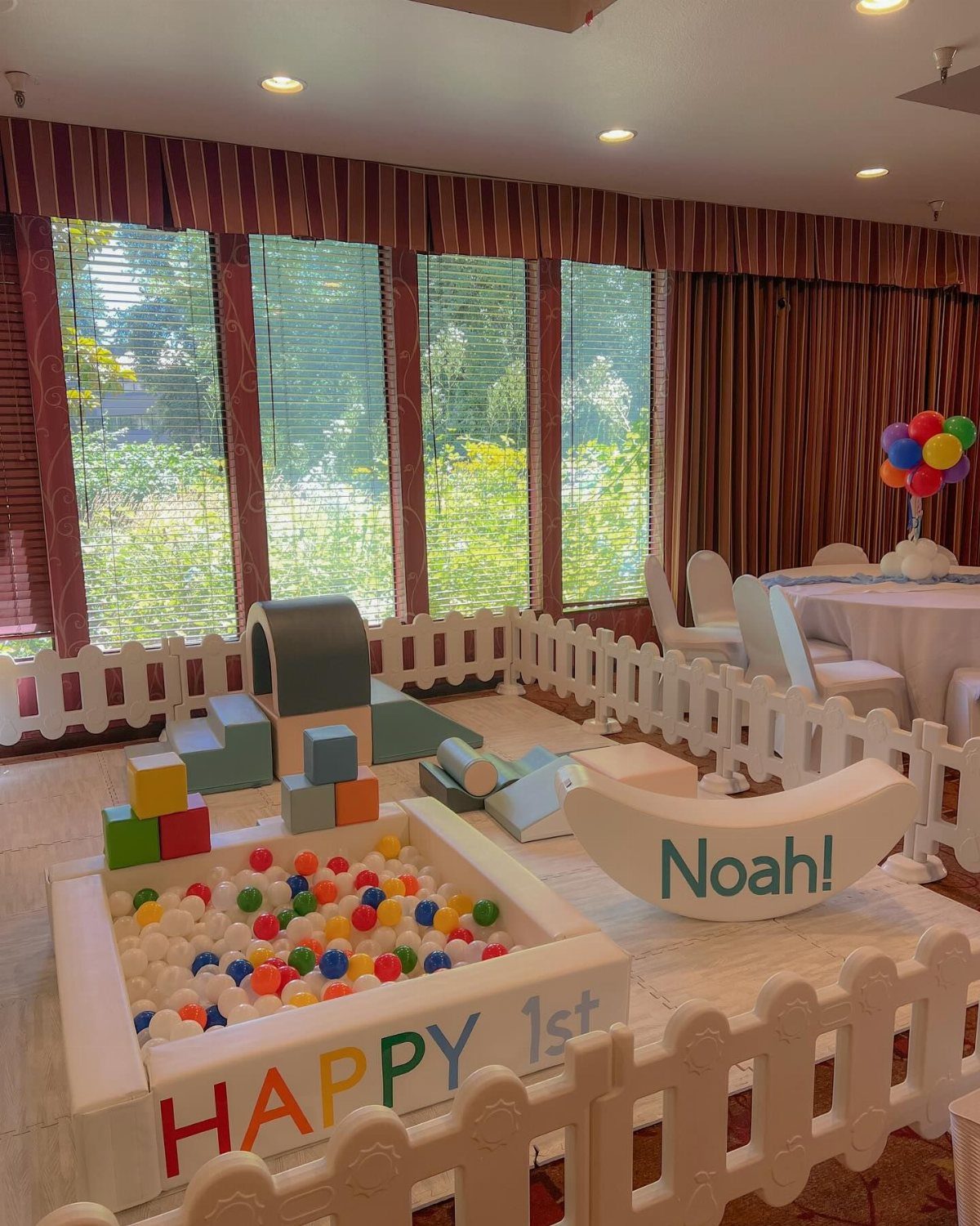 Baby birthday party setup with a ball pit and soft play foam blocks.