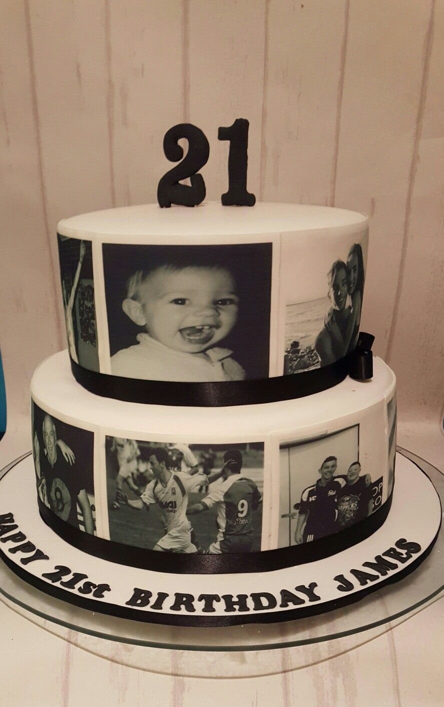 Two-tier white birthday cake with black ribbons and personal black-and-white photo decorations.