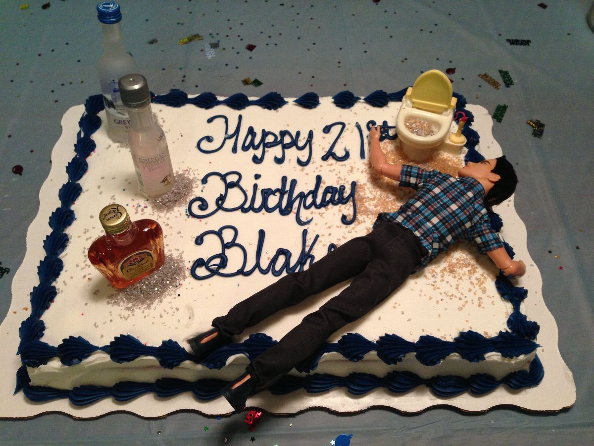 White frosted sheet cake with miniature liquor bottles and a man figurine lying down.