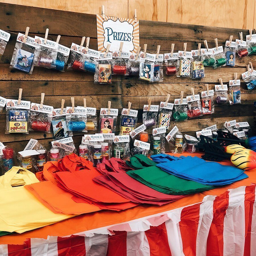 Carnival prize station with small toys clipped to wood and colorful fabric bags.