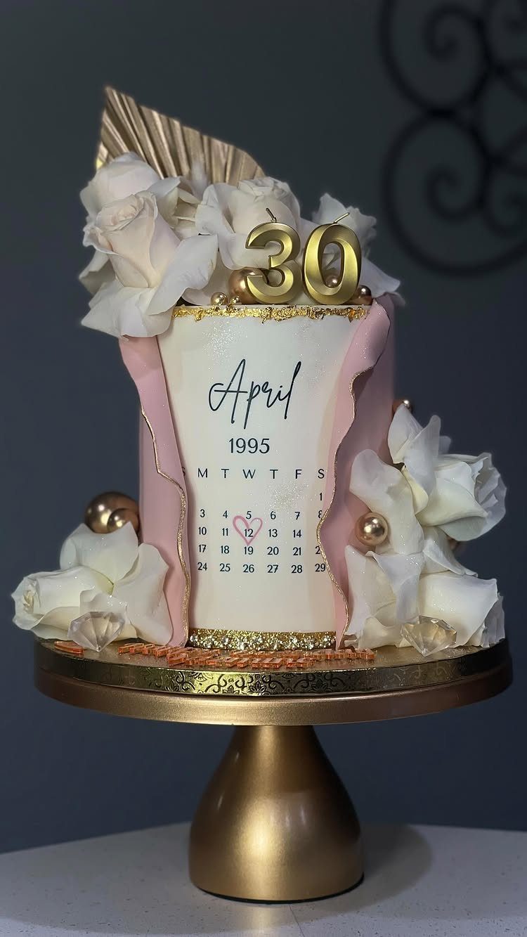 White birthday cake with a 1995 calendar, white roses, and gold 30 topper.