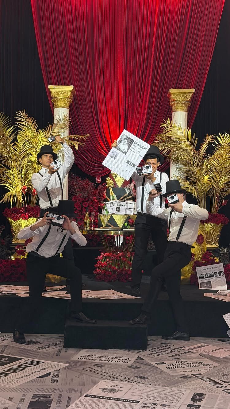 Vintage photographers in bowler hats posing before red curtains and gold columns.