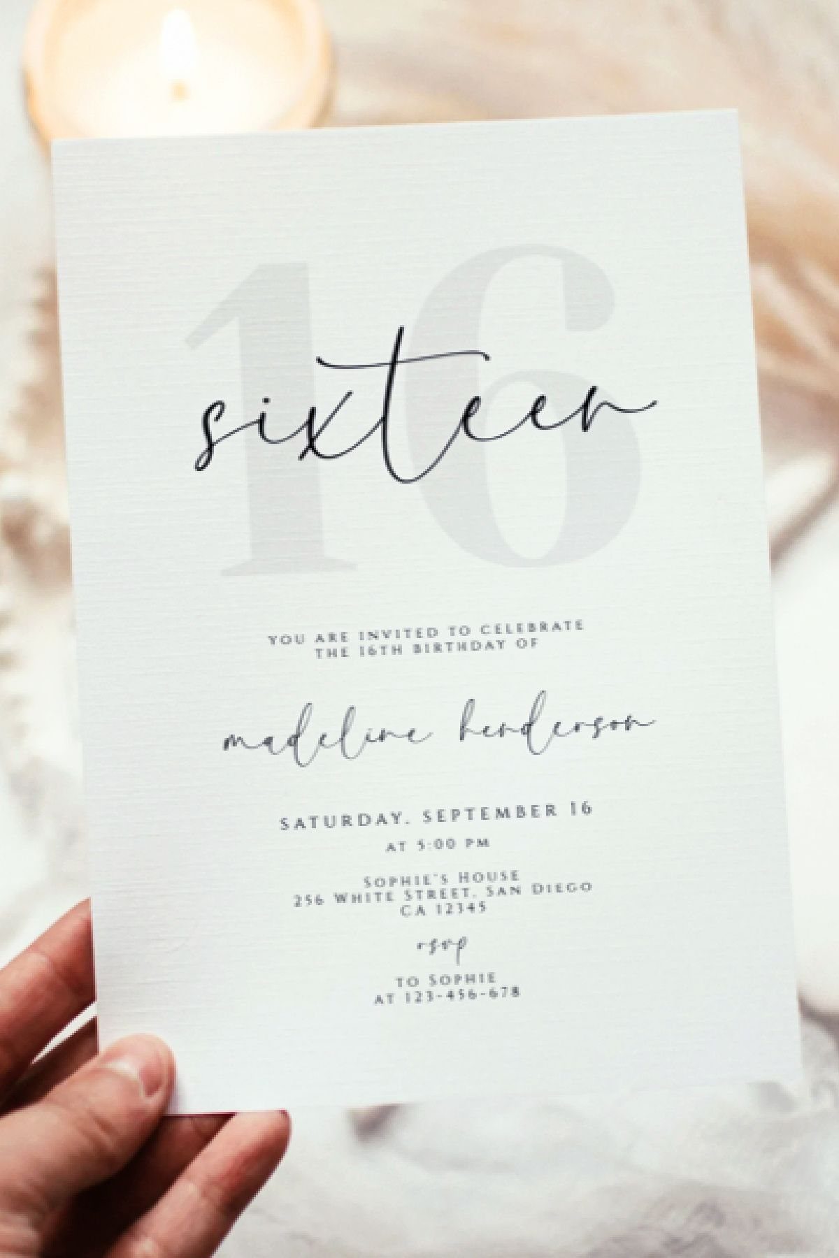 White 16th birthday invitation card with grey numbers and black cursive text.
